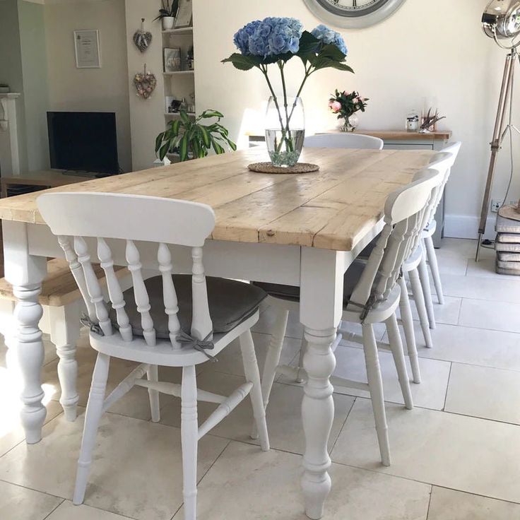 a wooden table with chairs around it and a clock hanging on the wall above it