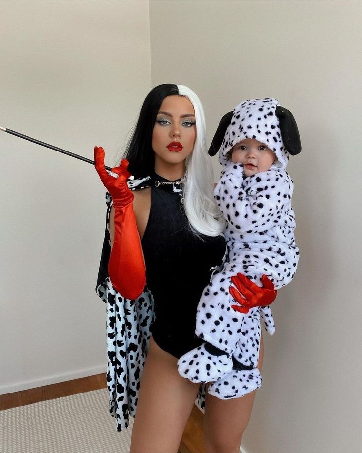 a woman and child dressed up in dalmatian costumes, one holding an umbrella