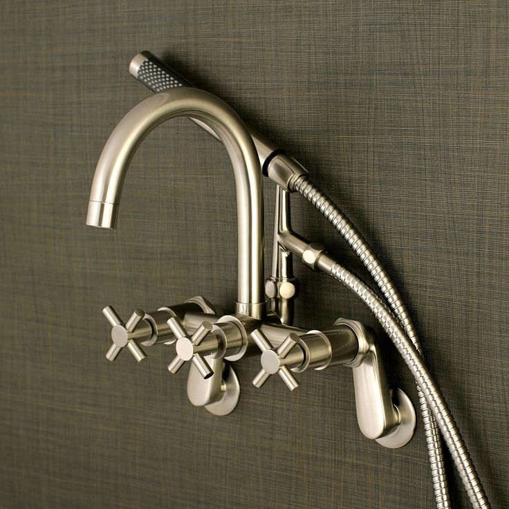 the faucet is attached to the wall with three hoses and two spray heads