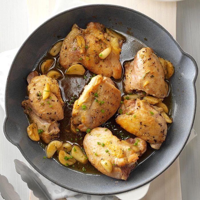 a pan filled with chicken and vegetables on top of a table