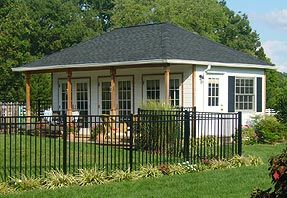 a small white house with a black fence around it