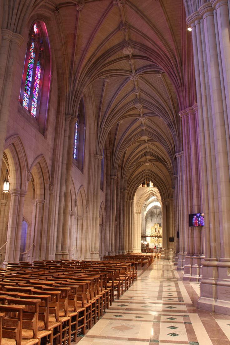 the inside of a church with rows of wooden pews