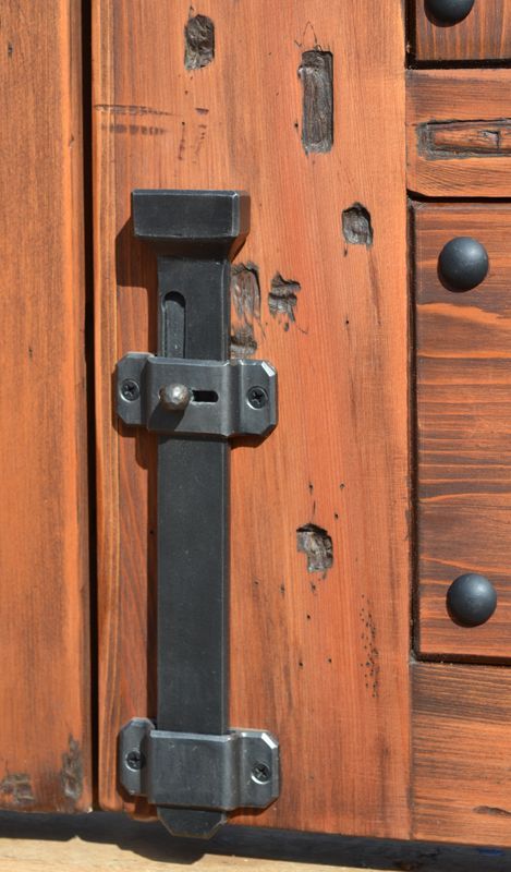 a close up of a wooden door with metal latches on the front and side