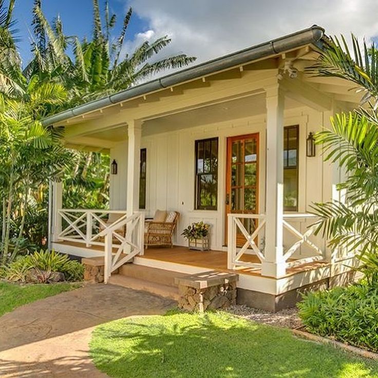 a small white house surrounded by palm trees