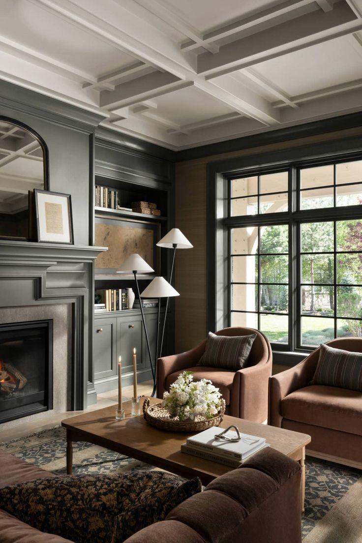 a living room filled with furniture and a fire place in front of a large window