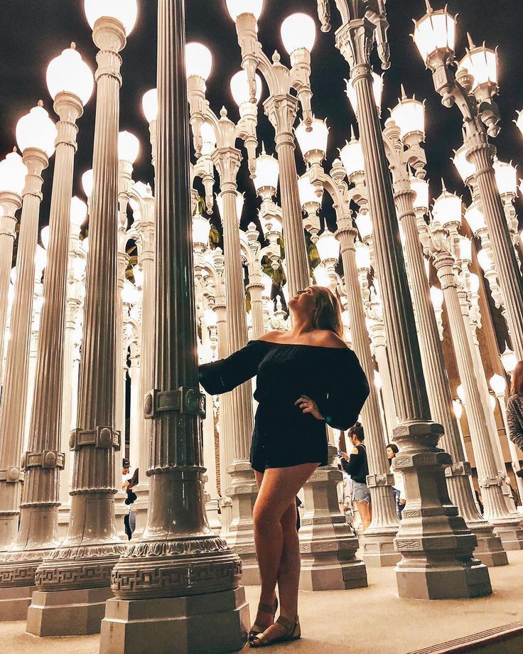 a woman standing in front of many street lamps