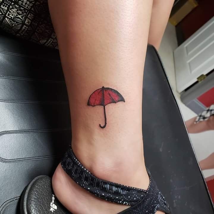 a small umbrella tattoo on the ankle