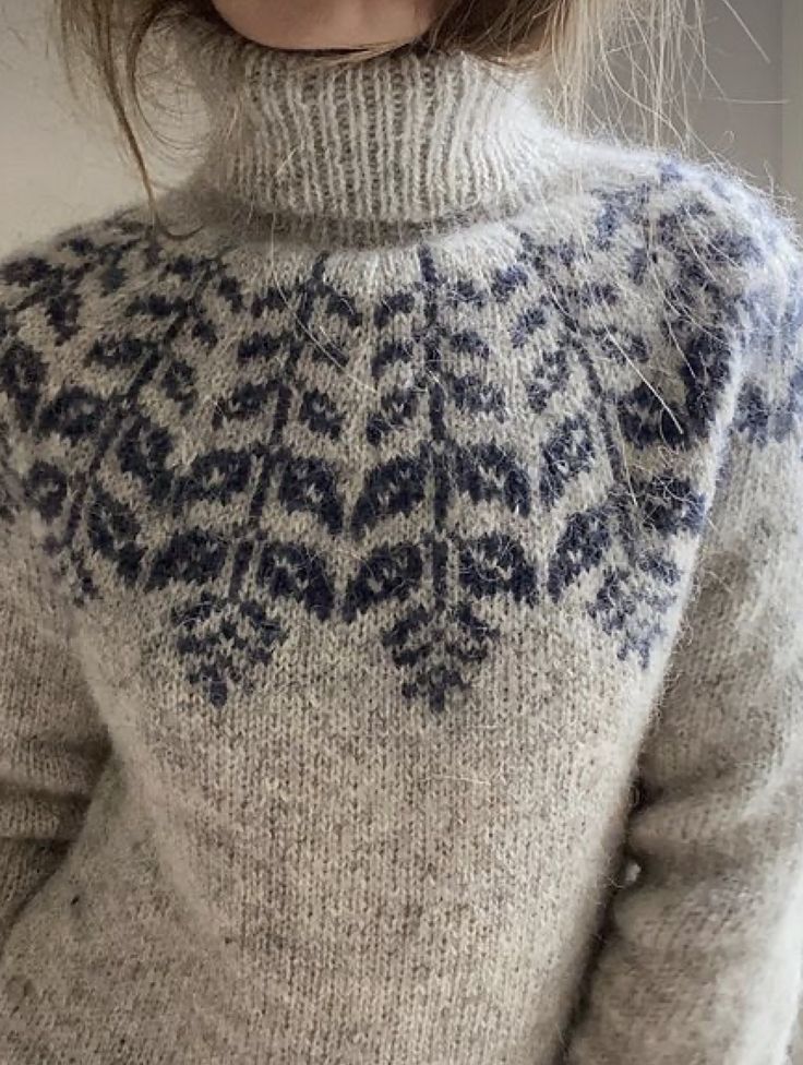 a close up of a person wearing a sweater with an intricate design on the back