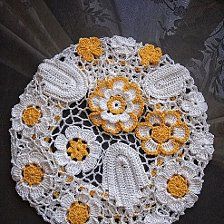 a crocheted doily with yellow and white flowers