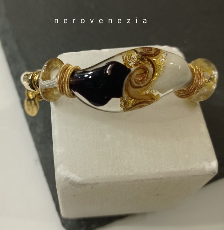 "Bracelet with central S-shaped wave-shaped pearl in imitation leather Murano glass The pearl is two-tone ivory and 35mm topaz with gold leaf and aventurine spiral motif entirely in Murano glass and two small cone-shaped pearls on the sides in crystal and gold. The bracelets are worn without the need to close them, inside a steel wire and externally in imitation leather (two different colors of your choice), which wraps your wrist in a fast, comfortable and safe way Excellent quality of material Elegant Gold Spiral Bracelet, Adjustable Glass Bracelets With Unique Variations, Elegant Silver Glass Bracelets, Elegant Glass Bracelets For Party, Elegant Glass Bracelets For A Party, Elegant Silver Bracelet With Glass, Elegant Handmade Glass Bracelets, Elegant Glass Bracelet Jewelry, Glass Bangle Jewelry Gift