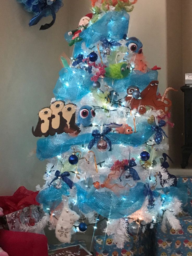 a christmas tree decorated with blue and white ribbons, fish ornaments, and other decorations