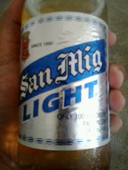 a person holding up a can of light beer in their hand with the label san diego light on it