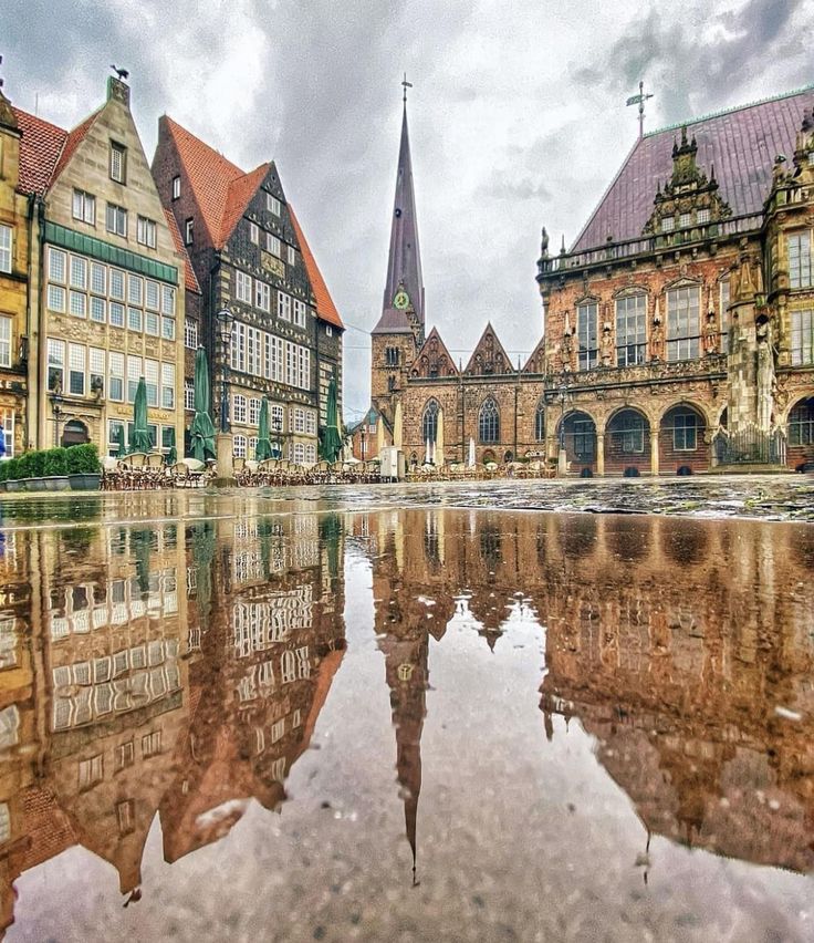 an old european town with water reflecting the buildings