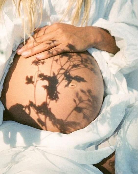 a pregnant woman's shadow on her stomach