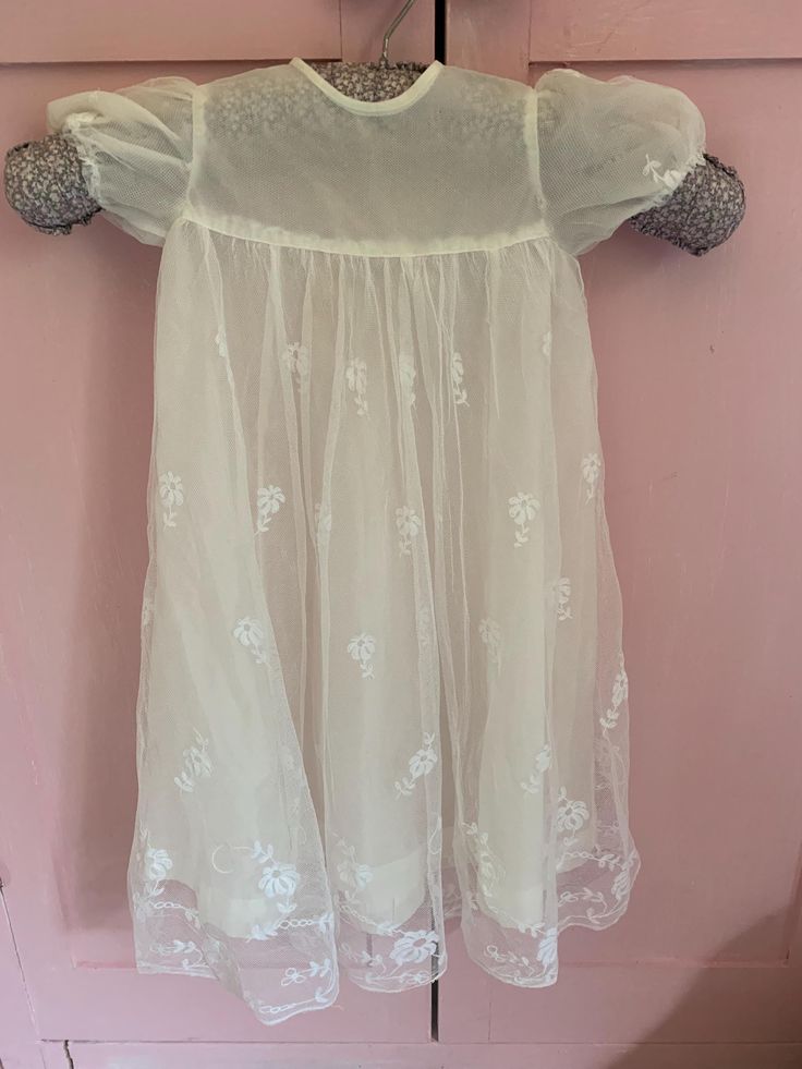 A very pretty vintage age christening or baptism gown. I think it probably dates from around the 1950s. It has a tulle / net and lace overskirt embellished with embroidered lace flowers and an artificial silk like underskirt. The sleeves are puffed and it is fastened at the back with tiny mother of pearl buttons.  It had been carefull made by hand. There are two loops just below the bodice where I presume there may have been a ribbon tie. You could add this if you wanted to. The length from the Vintage Broderie Anglaise Wedding Dress, Elegant Lace Baptism Dress, Vintage White Tulle Dress, White Baptism Dress With Lace Bodice For Dress-up, Fitted Baptism Dress With Lace Work For Spring, Vintage Summer Baptism Dress, Summer Vintage Baptism Dress, Vintage Summer Dresses For Baptism, White Vintage Fitted Baptism Dress