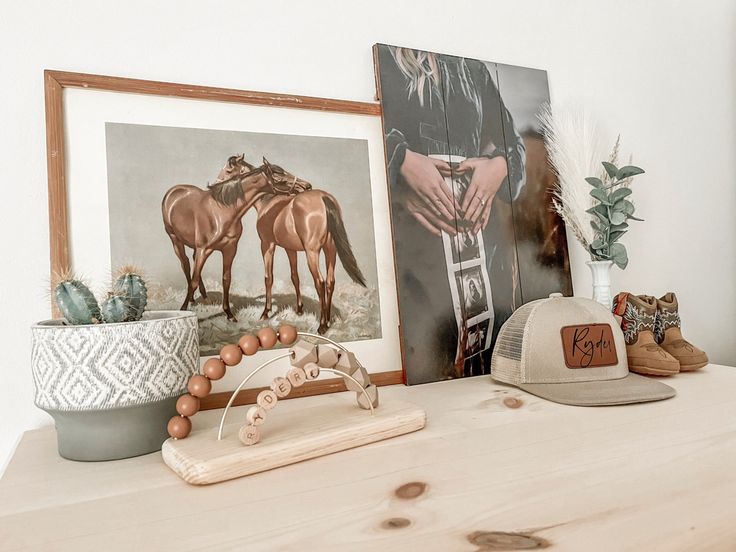 there are two pictures on the wall and one is in front of a hat, with other items nearby