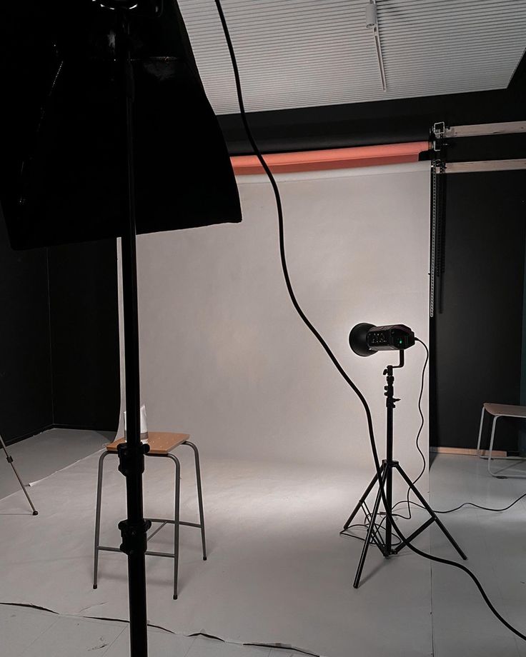 a photo studio with two chairs and one light