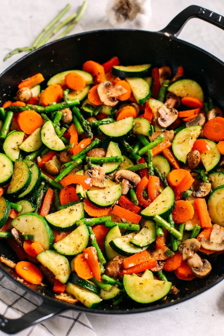 a skillet filled with vegetables and mushrooms