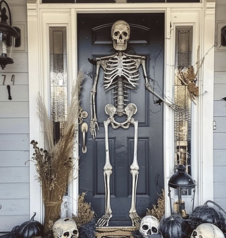 a front door decorated for halloween with skeletons and pumpkins