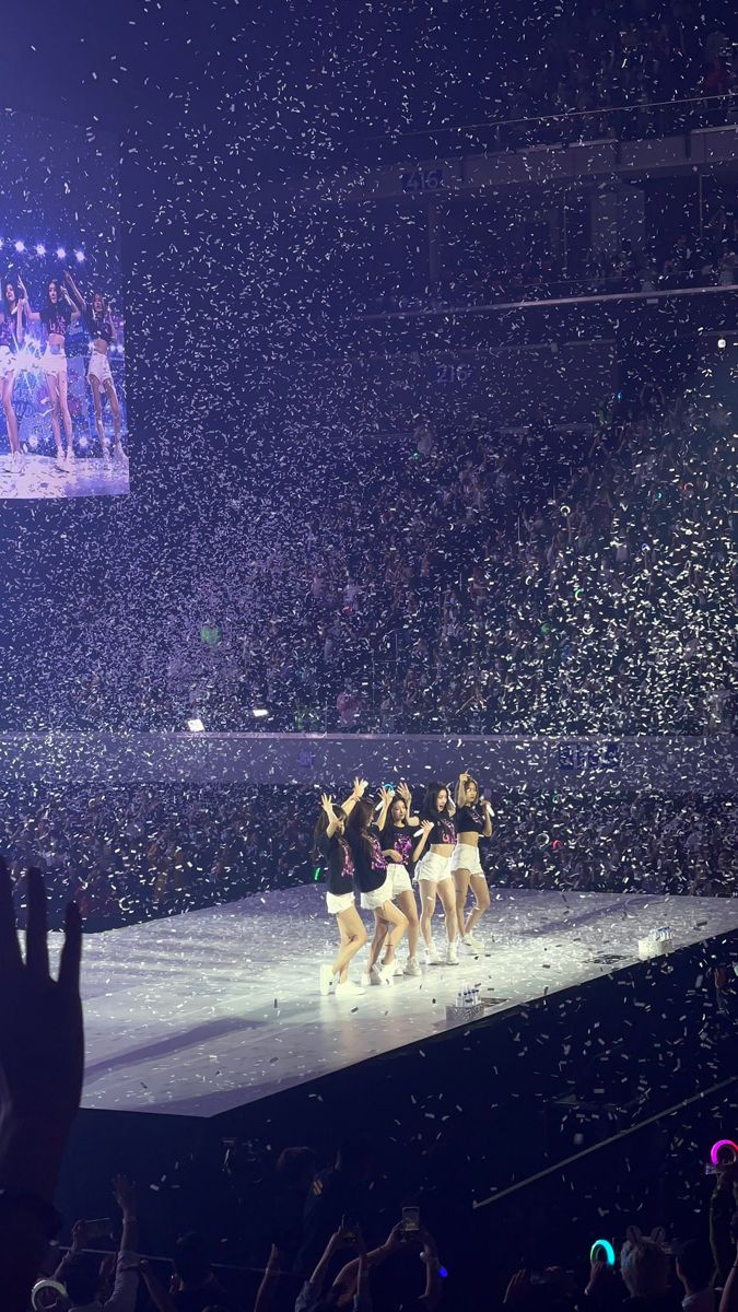 a group of people standing on top of a stage covered in confetti