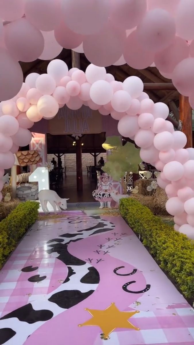 a pink and black decorated walkway with lots of balloons