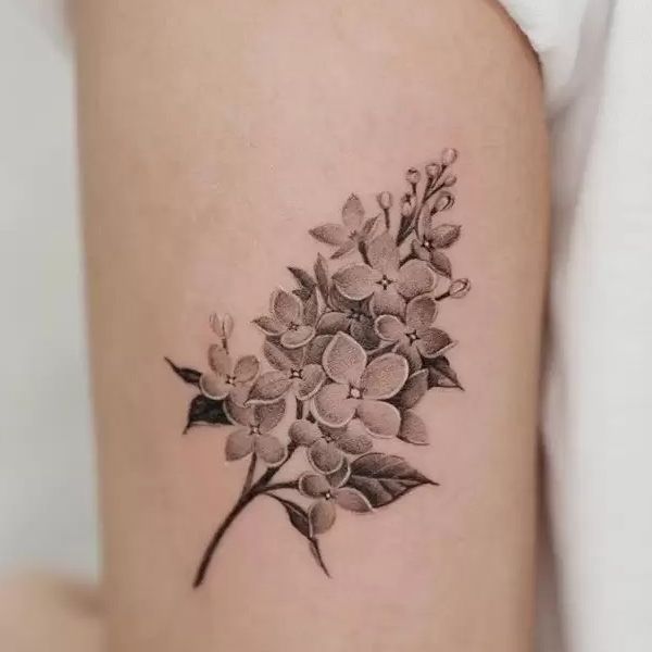 a black and white flower tattoo on the thigh