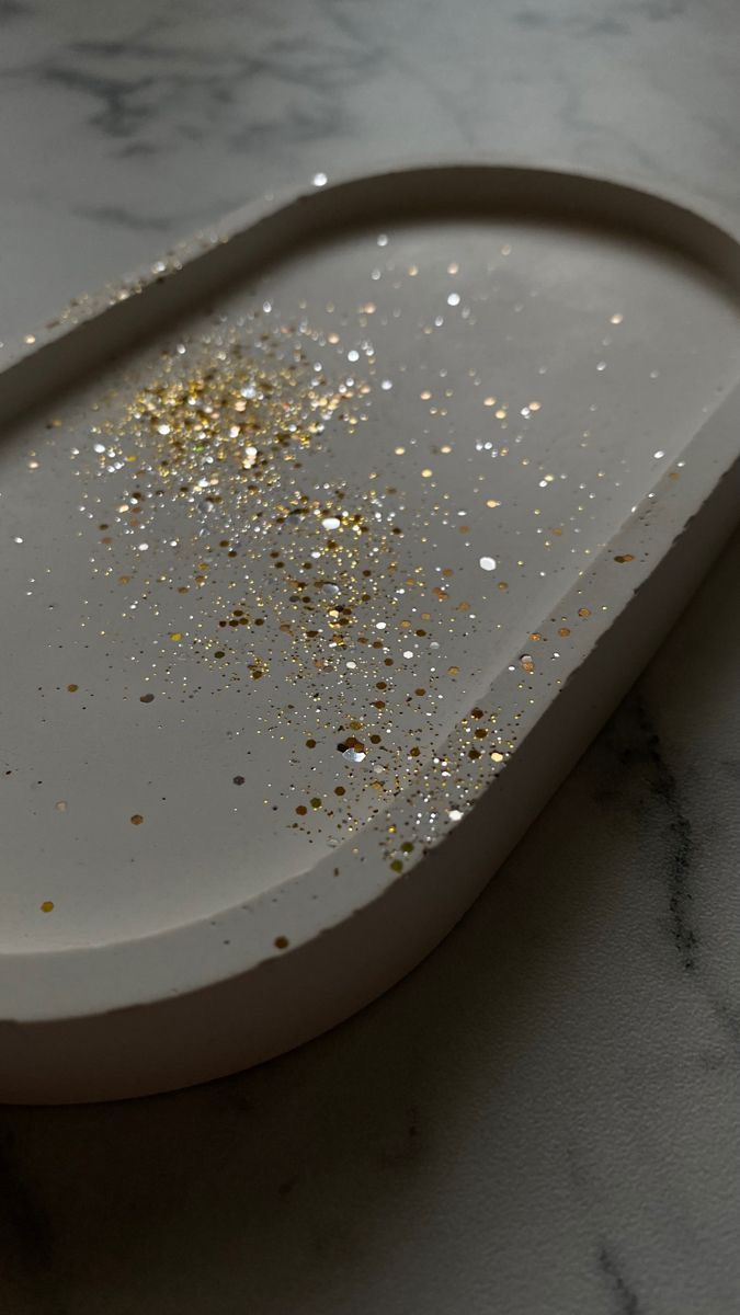 a white tray with gold sprinkles on the top and bottom, sitting on a marble countertop