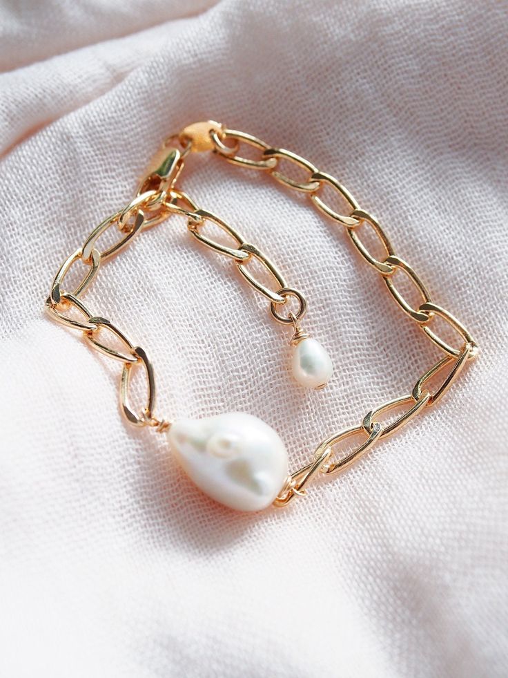 This baroque pearl bracelet feels like it was plucked straight from the ocean. Luminous and organically shaped, it is striking solo or worn in multiples for a stunning statement.✦ DETAILS ✦✧ Name: Keali'i (keh-AH-lee-ee) - the monarch.✧ Adjustable up to 8 inches.✧ Genuine Freshwater Baroque Pearl.✧ 18kt gold filled chain with lobster clasp.✧ All Ke Aloha Jewelry pieces come packaged thoughtfully, beautifully, and ready for gift giving.✧ Unless otherwise noted in the listing description, all piec Adjustable Baroque Pearl Drop Bracelets, Baroque Pearl Charm Bracelet, Baroque Pearl Drop Bracelet, Adjustable Baroque Pearl Bracelet With Oyster Detail, Adjustable Baroque Pearl Bracelet, Adjustable Oyster Bracelet With Baroque Pearls, Gold Pearl Bracelet, Simple Hoop Earrings, The Monarch