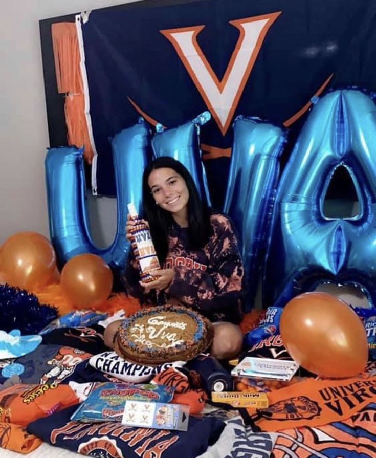 a woman sitting in front of a table filled with balloons and other items that spell out the word va