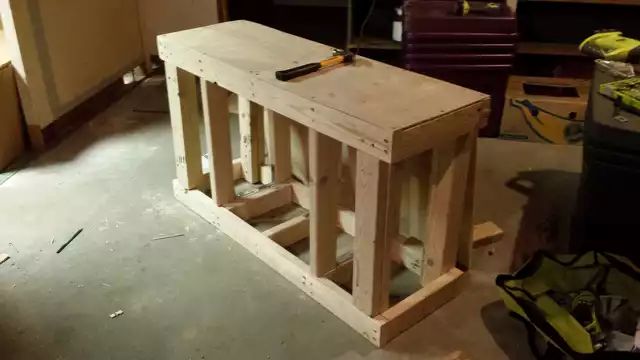 a wooden table sitting in the middle of a room with tools on top of it