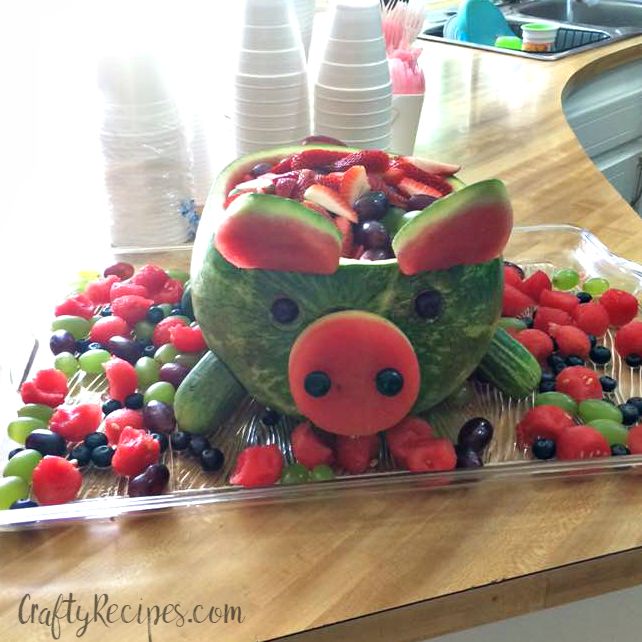 a cake made to look like a pig with fruit in the shape of his face