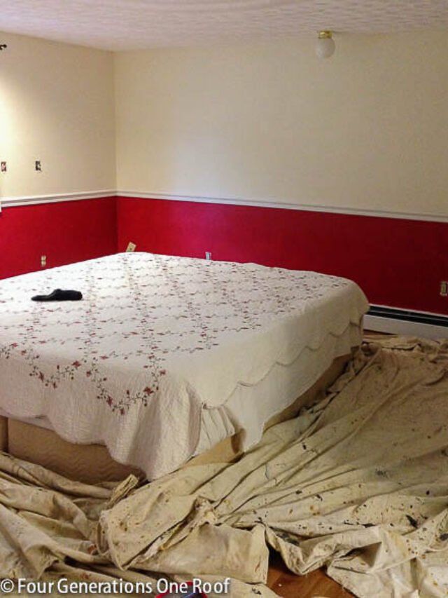 a bed in a room with red walls and sheets on the floor