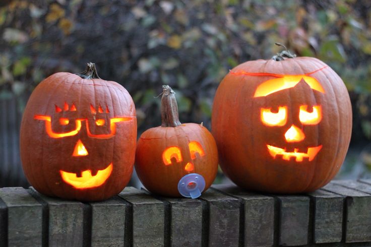 three pumpkins with faces carved into them