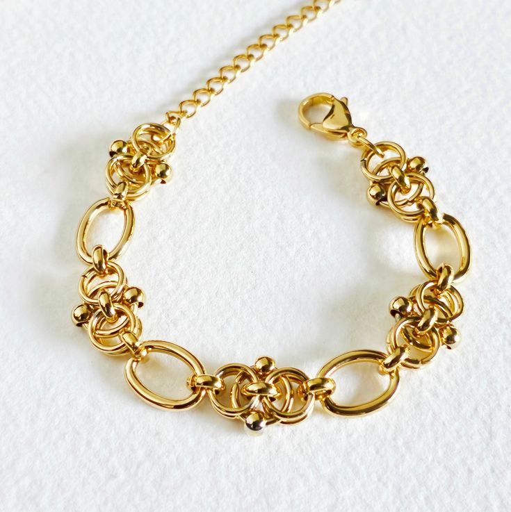 Description Elevate your accessory game with our handcrafted gold bracelet, featuring a unique and intricate chain link design that stands out with elegance. Each link is meticulously crafted to create a stunning pattern, offering a distinctive look that’s both sophisticated and versatile. Made from tarnish, fade, and water-resistant 18kt gold, this bracelet ensures long-lasting shine and durability. Whether worn alone or paired with other pieces, this exquisite bracelet is the perfect blend of Luxury Tarnish-resistant Chain Ring For Formal Occasions, Yellow Gold Link Bracelet In Brass, Elegant Brass Bracelets With Rectangular Links, Gold Link Bracelet In Brass Chain Style, Timeless Metal Bangle Chain Bracelet, Luxury Metal Bangle Chain Bracelet, Elegant Gold-tone Chain Ring For Gift, Elegant Gold Oval Link Chain Ring, Gold-tone Brass Bracelets With Solid Link