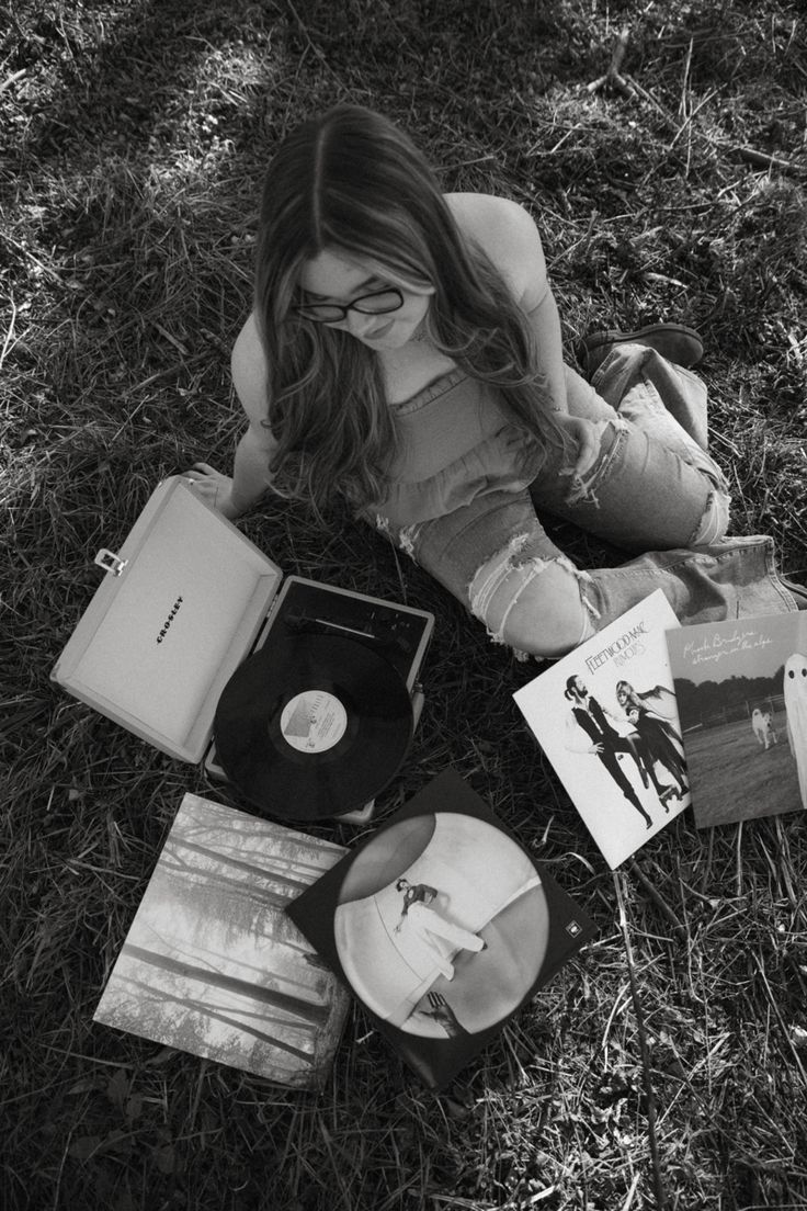 a woman laying on the ground with her head down next to an album and cd