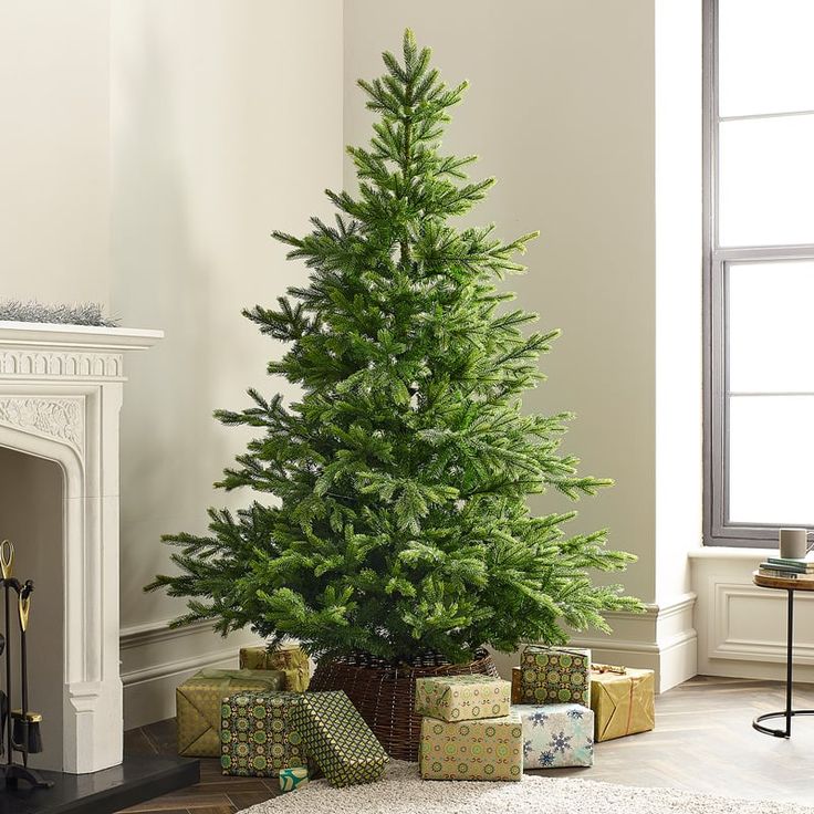 a christmas tree in a living room with presents under it