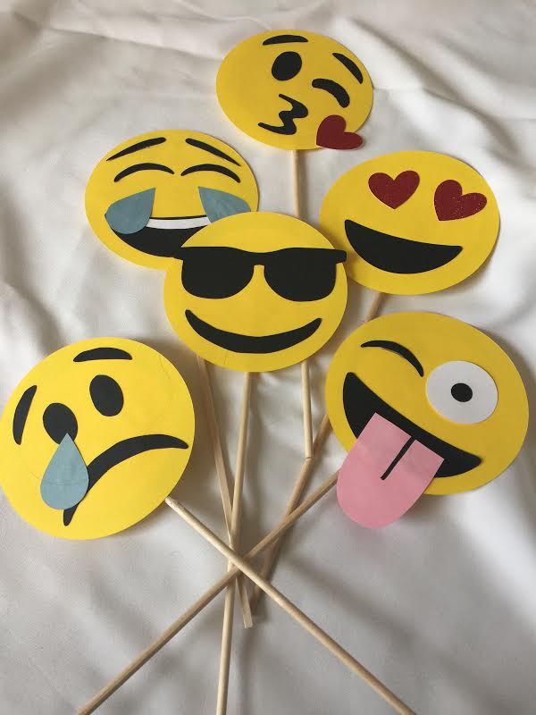 four smiley face cupcake toppers on a stick with sunglasses and tongue sticking out