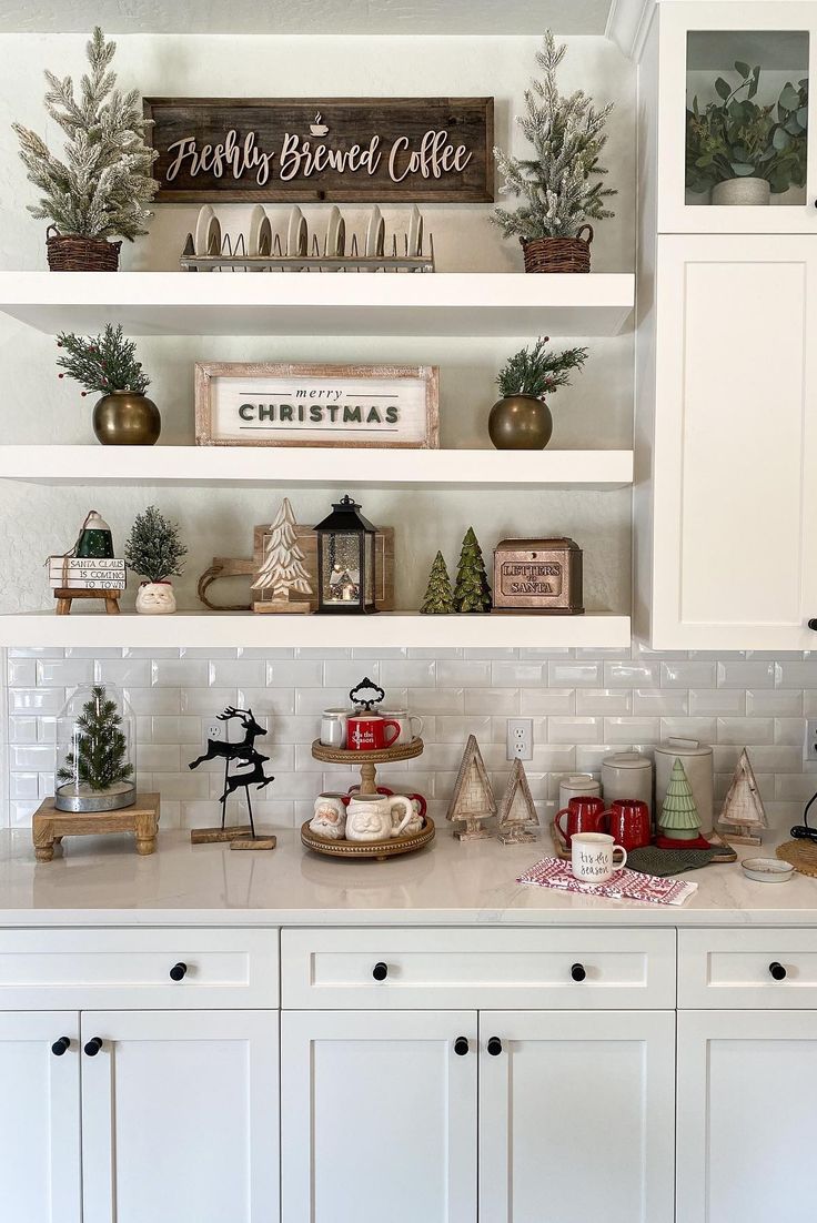 a kitchen with white cabinets and christmas decorations on the counter top, along with holiday decor