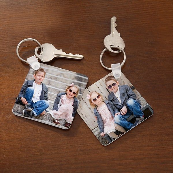 two keychains that have pictures of people on them and one has a pair of sunglasses