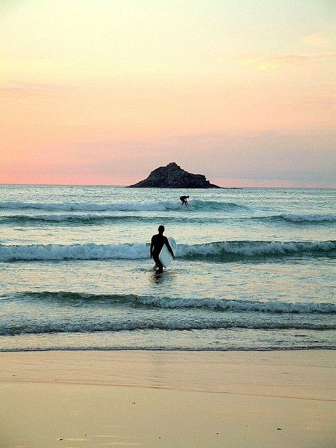 a man in the ocean holding a surfboard