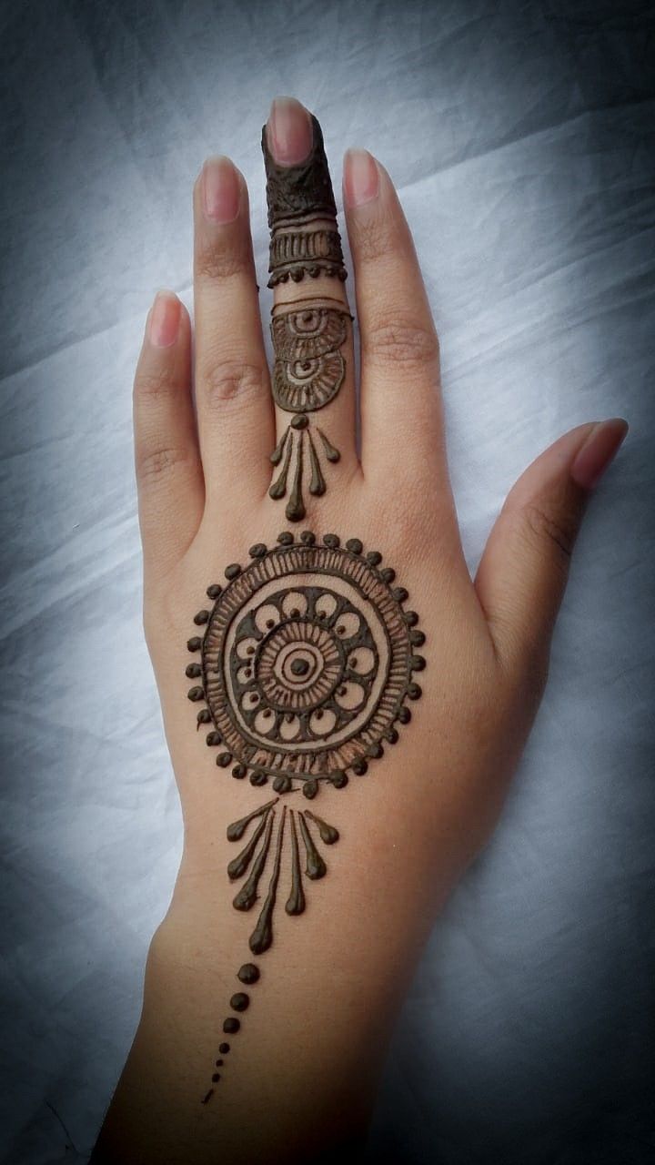 a woman's hand with henna tattoos on it