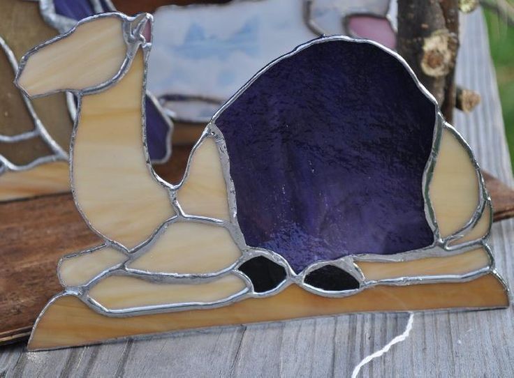 a stained glass piece sitting on top of a wooden table