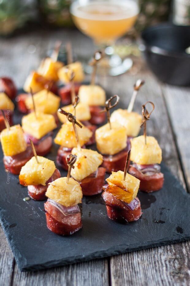 small appetizers are arranged on a slate platter