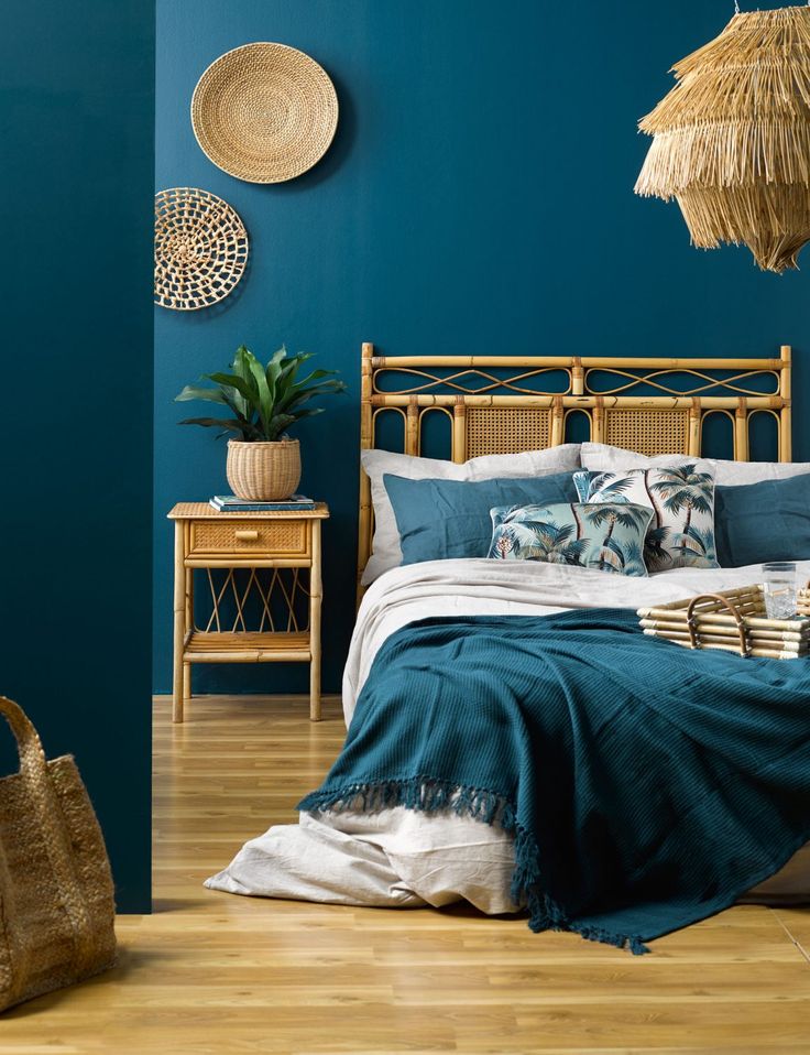 a bedroom with blue walls and wooden furniture in the corner, including a bamboo headboard