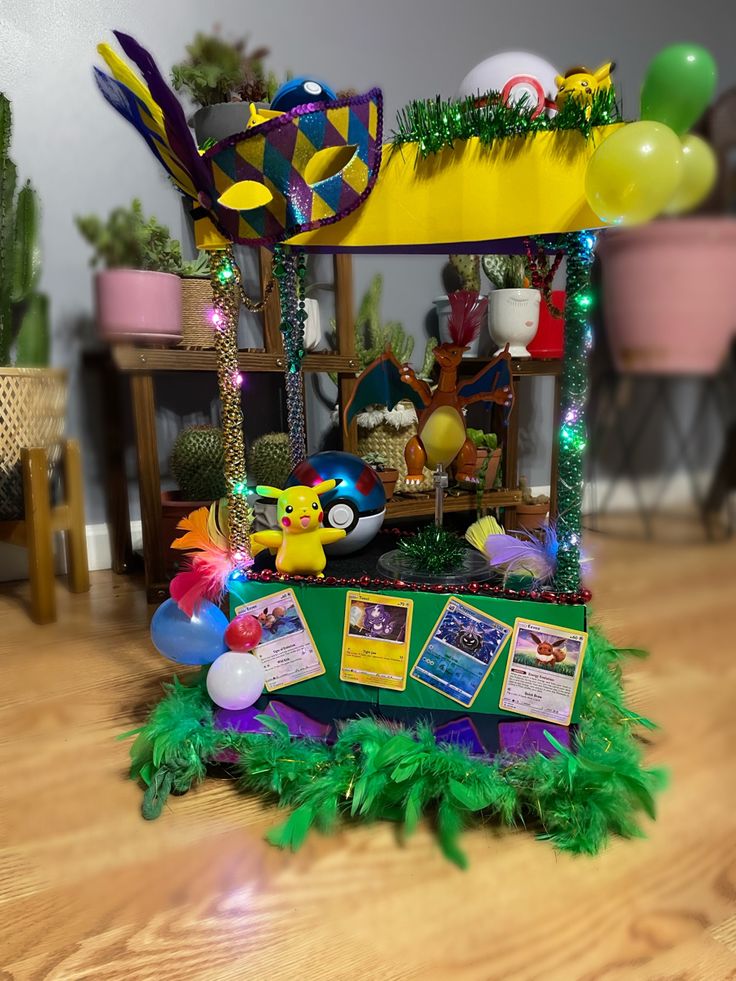 a display case on the floor with balloons and decorations around it, in a room decorated for mardi gras