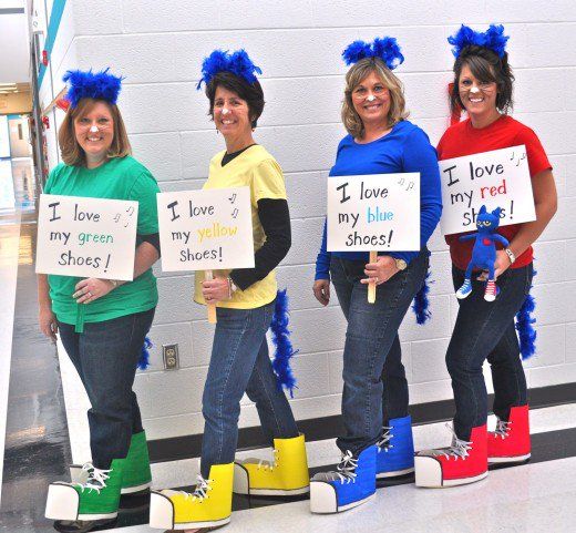 four women holding signs that say i love my blue shoes and i love my yellow shoes