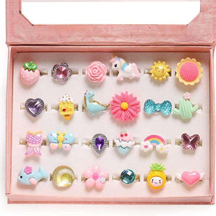 a pink wooden box filled with lots of different types of hair clips and brooches