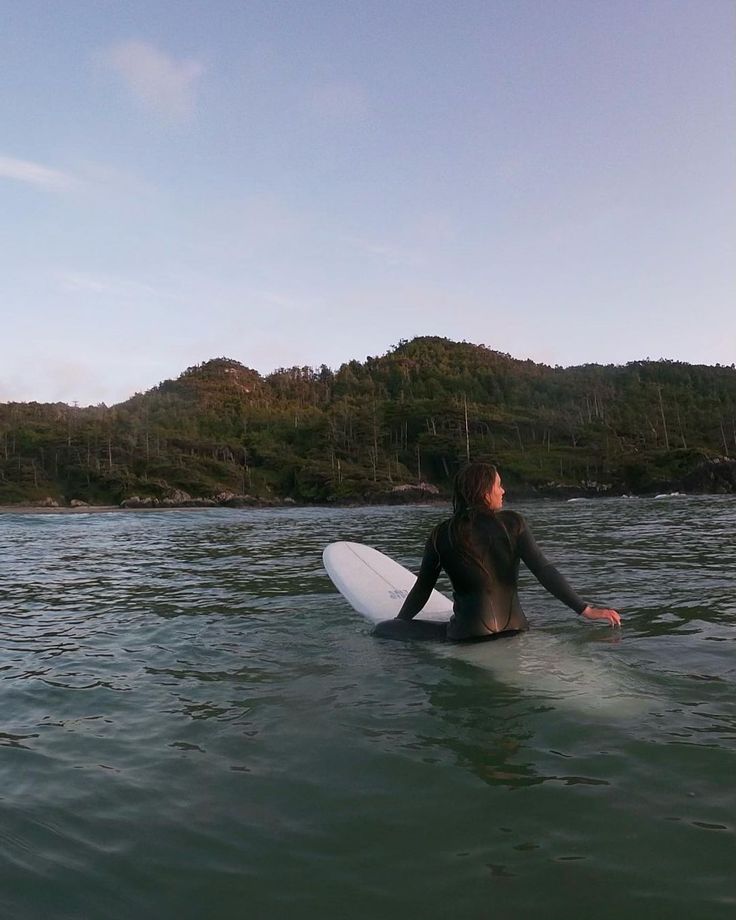 a person sitting on a surfboard in the water