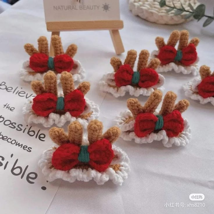 four crocheted teddy bears with bows on them sitting on top of a table