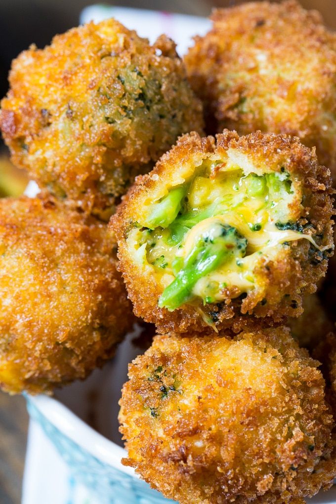 some fried food is in a blue bowl on a table with broccoli sprouts